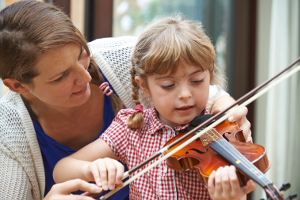 violin instructor teaches young girl