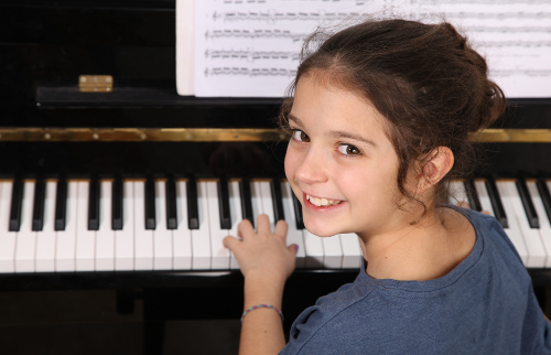 Girl at piano looks back