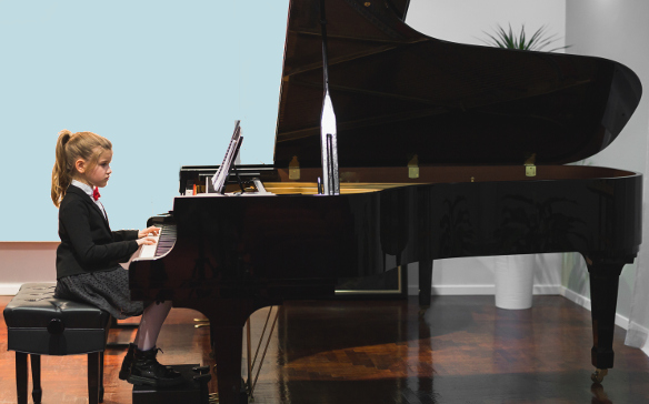 Girl playing at piano recital