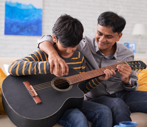 Dad helps son with guitar